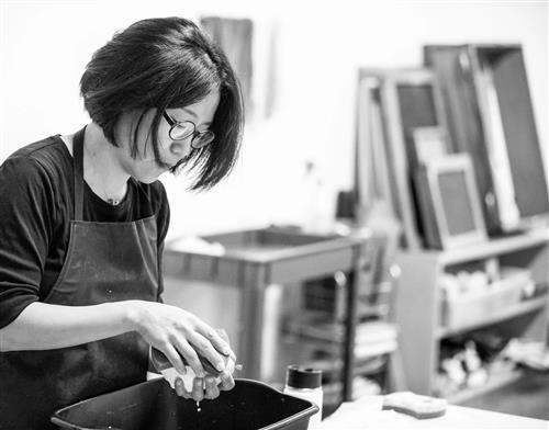 black and white photo  of woman in an art studio